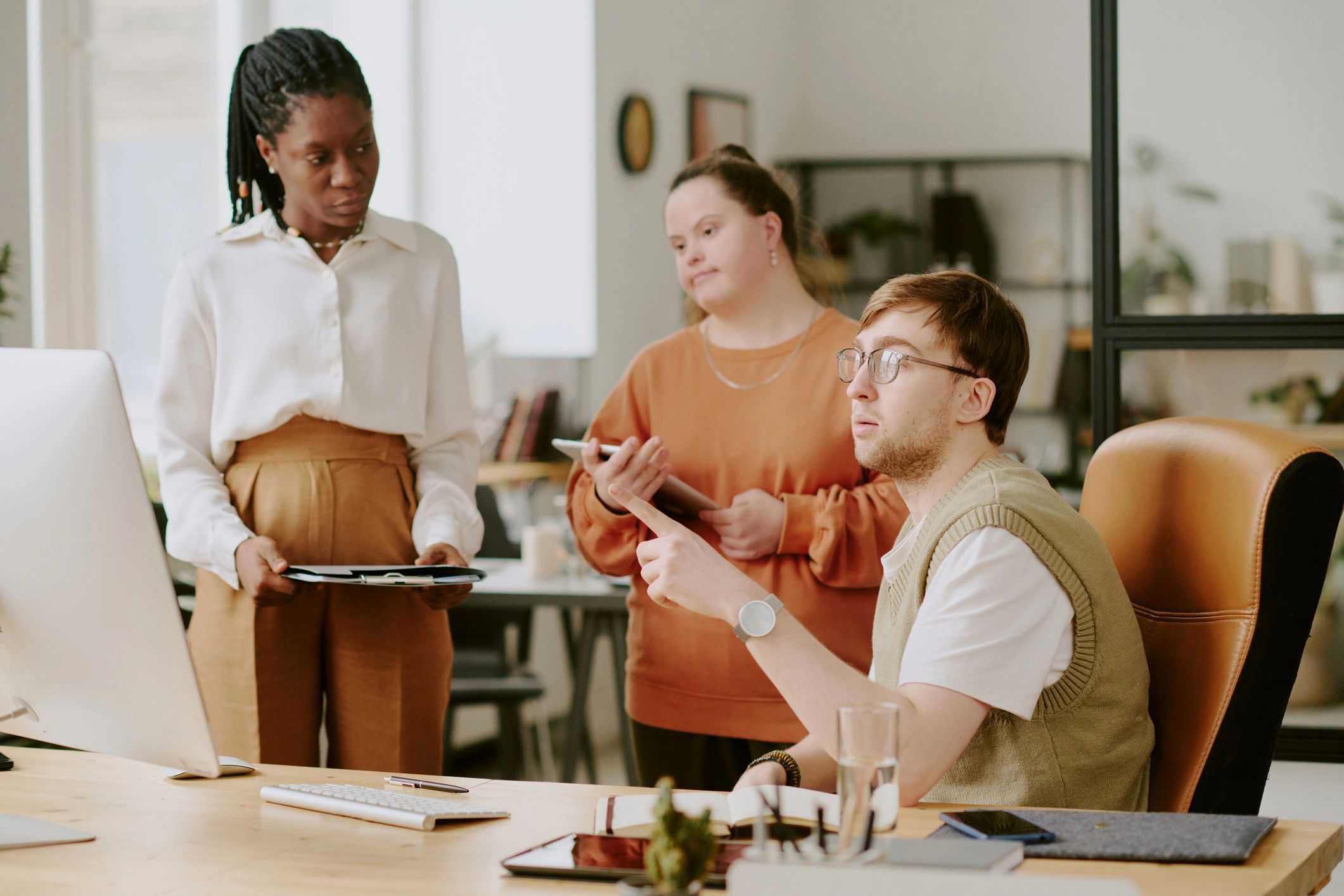 Creative team collaborating around a computer while planning work